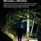 Person walking through a forest with a Klarus flashlight, highlighting dual-core power and reach features.