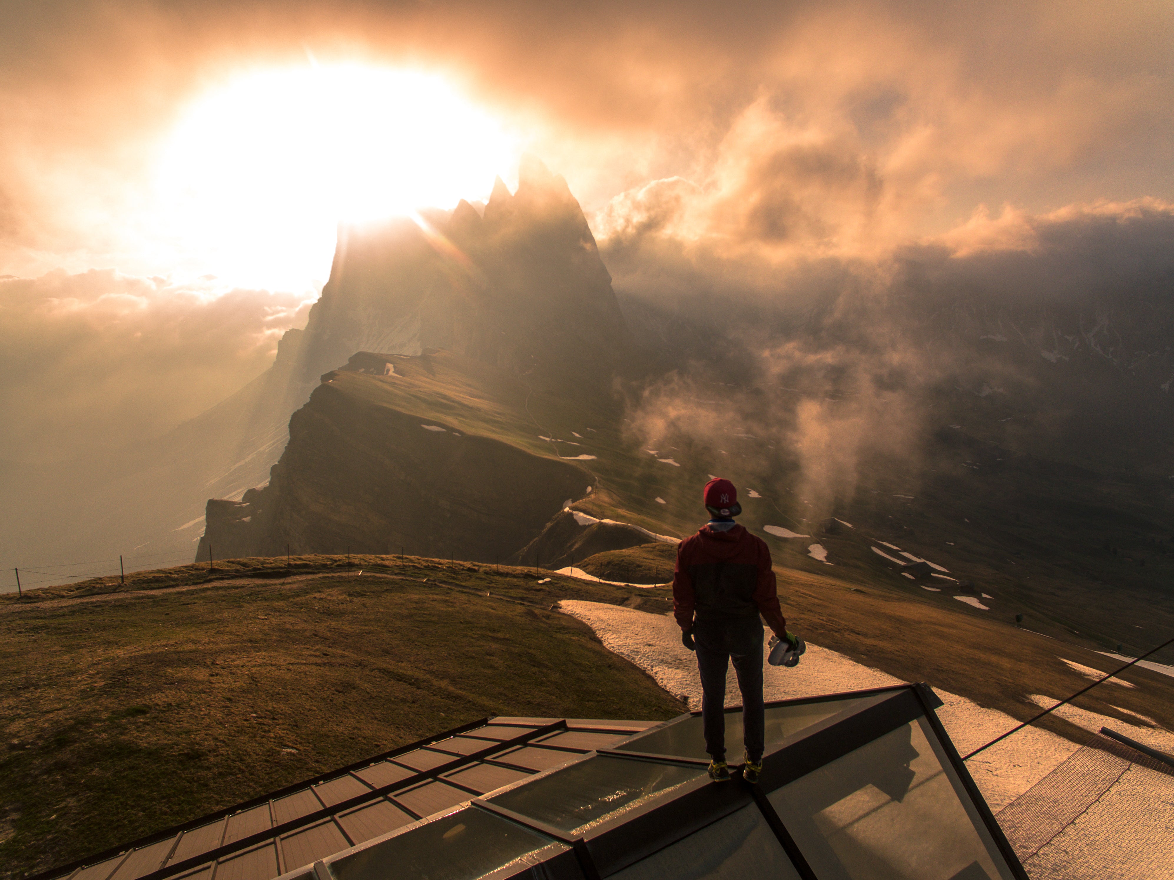 a person standing on a roof overlooking a mountain range